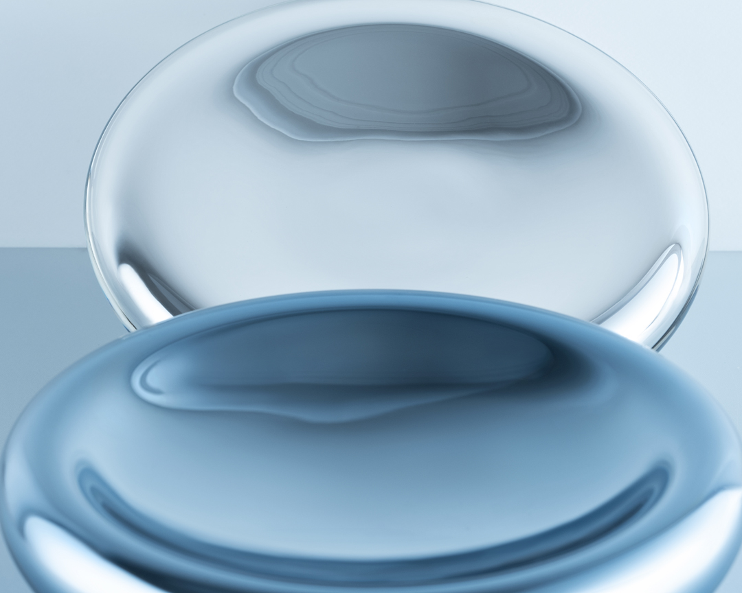 Abstract image with two translucent blue spheres, one clear and one opaque, creating a visually interesting studio art composition.