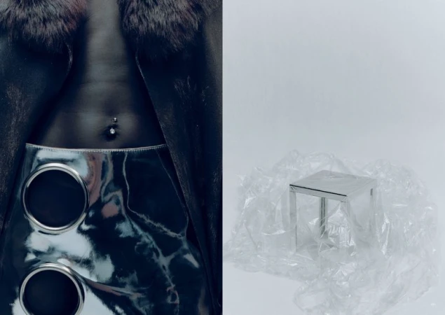 Fashion editorial shot featuring a torso with a piercing, a skirt with large metal circles, and a fur-collared coat against a stark white backdrop.