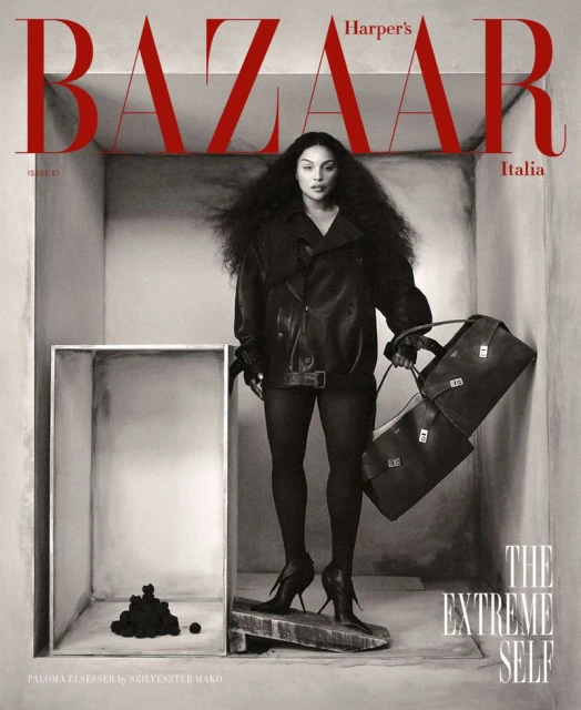 Fashion magazine cover featuring a woman with voluminous hair wearing a black leather jacket, holding a handbag, in a geometric setting.