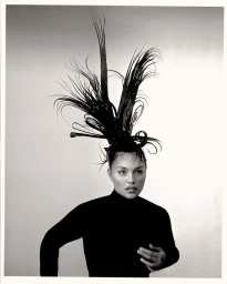 Paloma Elsesser in a black turtleneck with elaborate avant-garde updo hair against a light background for Harper's Bazaar Italia
