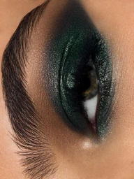 Close-up macro shot of an eye featuring dark green eyeshadow and groomed eyebrows for Elle Croatia
