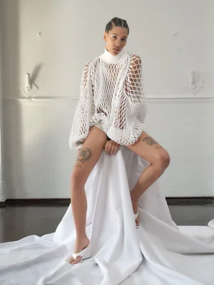 Kai Isaiah Jamal wearing white fishnet top and seated on draped white fabric for Re-Edition Magazine