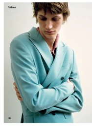 Model wearing a light blue double-breasted suit jacket against a plain white background