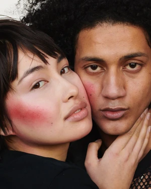Close-up portrait of two models with flushed blush on cheeks posing tightly together for Mirror Mirror Magazine