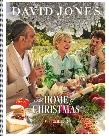 David Jones Christmas gift guide 2024 with three people sitting at an outdoor table laden with festive food and greenery.