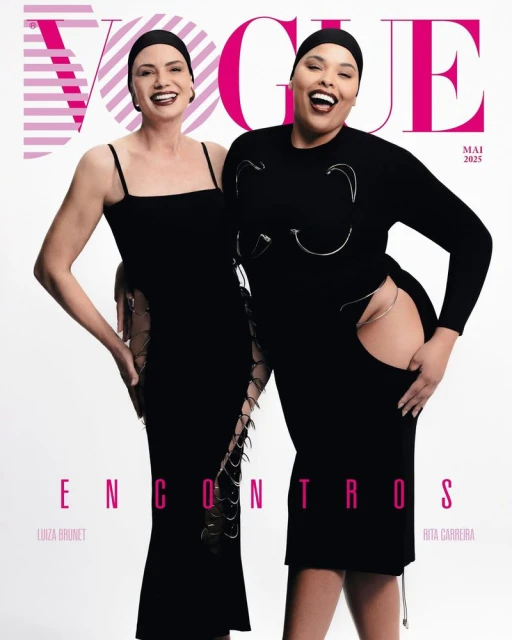 Two women pose on a Vogue cover, one wearing a black strappy dress and the other a long-sleeved dress with silver embellishments.