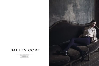 Model Anna Virzi reclining on a velvet chaise longue against a distressed wall for Posh Magazine editorial.