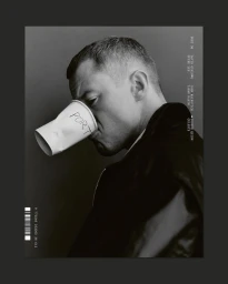 Black and white portrait of actor Joseph Quinn holding a crushed white paper cup reading PORT over his face for Port Magazine.