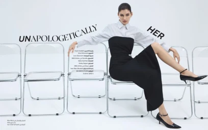 Model Valery Kaufman seated across transparent folding chairs in a black and white outfit for Marie Claire Arabia