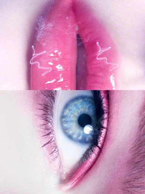 Close-up shot of a blue human eye with pink eyeliner and glossy pink lips with white squiggles, creating a surreal and artistic beauty image.