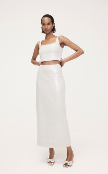 Model in white crop top and matching long skirt posing against a seamless white background for Witchery