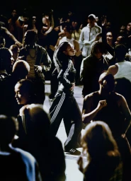 Group of dancers in dark athletic apparel performing in a dimly lit space for the Adidas Original Campaign