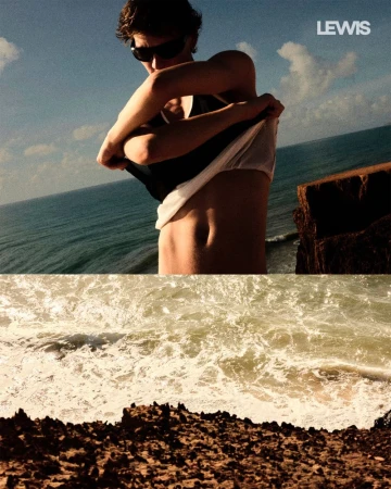 Man on cliffside removes shirt overlooking sea. Features blue sky, waves crashing on rocks, with 'Lewis' logo in corner, in warm light.
