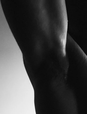 Close-up black and white photo of the arm of an adult, the arm is muscular and shows skin texture with soft, diffused lighting.