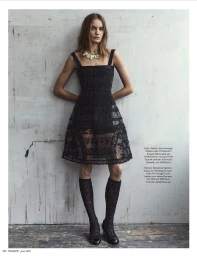 Model Nina Marker wearing a black lace dress and patterned knee-high socks against a weathered concrete wall for Madame Germany.