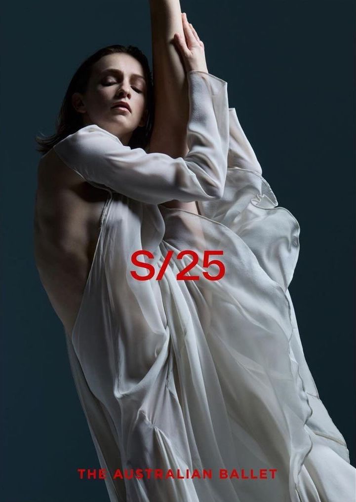 Female ballet dancer in flowing white dress poses gracefully in a studio against a dark background, showcasing a delicate and artistic movement.