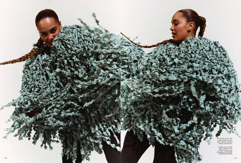 Editorial fashion shot featuring two adult females wearing textured blue clothing against a bright white studio backdrop with braids.