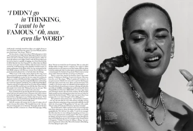 Black and white portrait of Jorja Smith with a long braided ponytail and layered silver chain necklaces against a white background