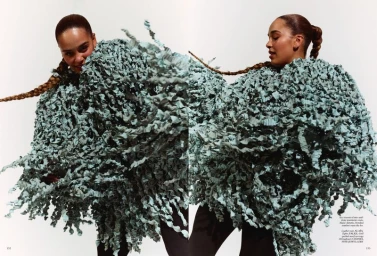 Jorja Smith wearing a textured fringe cape coat against a white background for British Vogue
