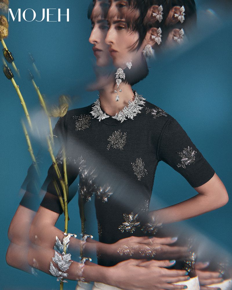 Multiple exposures of a woman wearing a gray sweater with jeweled embellishments, a matching necklace, and earrings on a blue background.