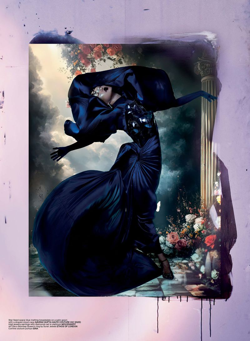 A woman in a blue gown strikes a pose within a framed artwork featuring a classical column and painted floral accents, under studio lighting.