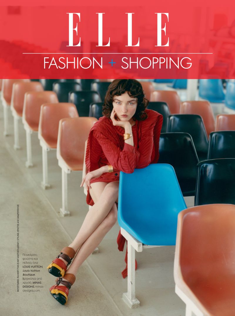 Elle Magazine cover featuring a woman in a red dress sitting on a blue stadium chair, with rows of empty stadium seats in the background.