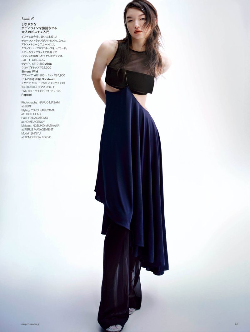 A stylish fashion shot featuring a slender Asian woman in a modern black and blue dress against a bright, clean background. Studio lighting.