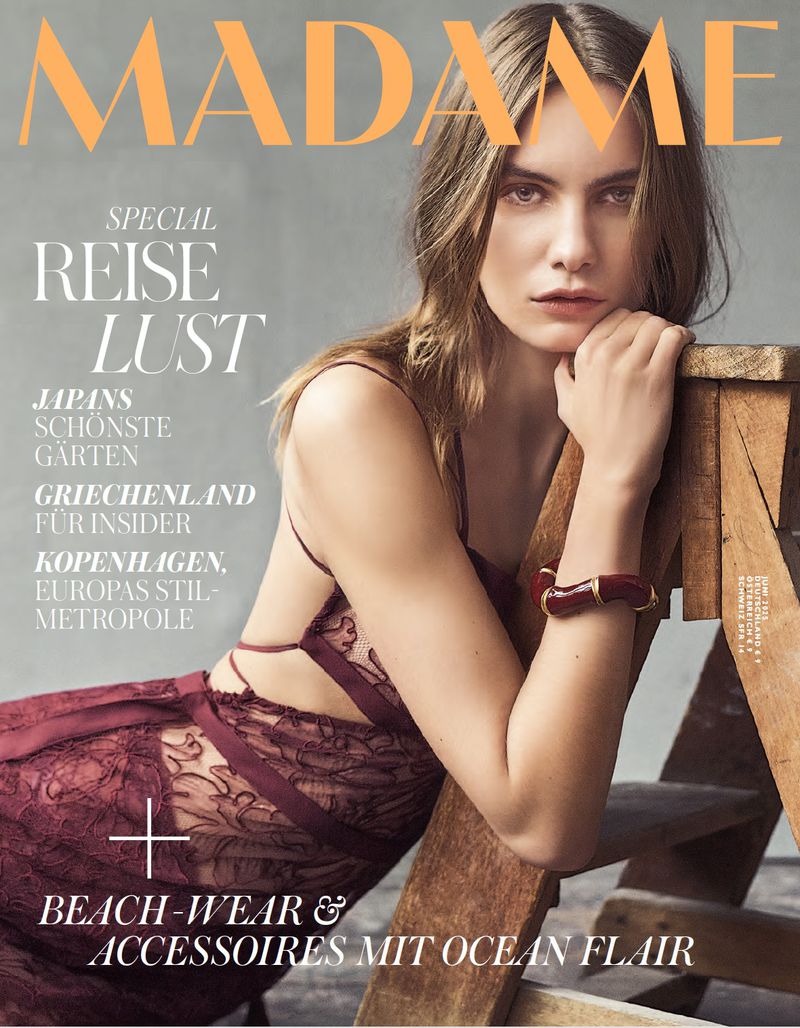 Madame magazine cover featuring a model wearing a maroon dress, posed next to a wooden ladder. The magazine title is at the top.