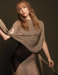 Suki Waterhouse in a striped brown knit top and skirt against a dark olive background for Elle Japan