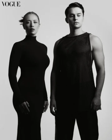 Monochrome studio shot featuring a woman in a form-fitting dress and a man in a mesh tank top, set against a light grey background.