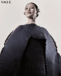 Model wearing a dark pleated sculptural garment against a light background for Vogue Philippines editorial