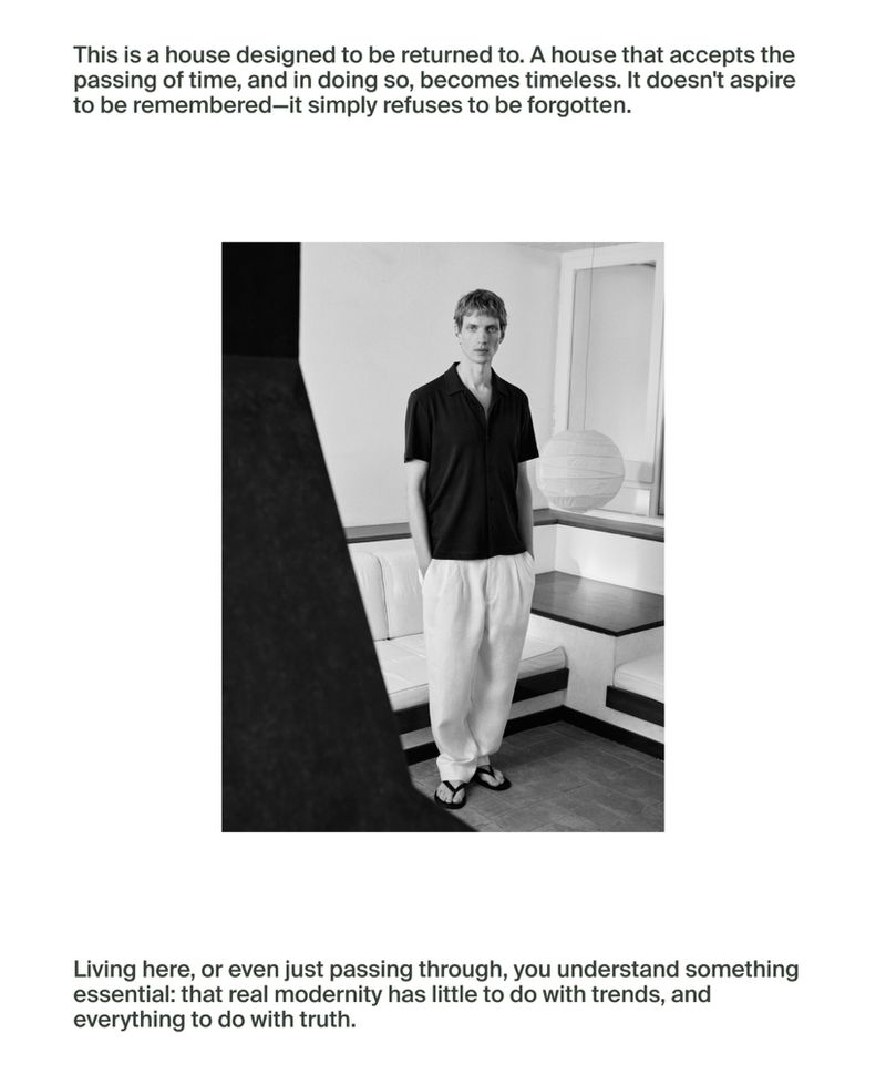 Monochrome portrait of a male in casual dark shirt and light pants, standing in an interior with a bench and window, with text above and below.