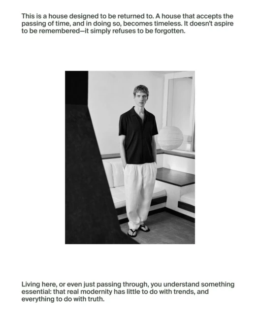 Monochrome portrait of a male in casual dark shirt and light pants, standing in an interior with a bench and window, with text above and below.