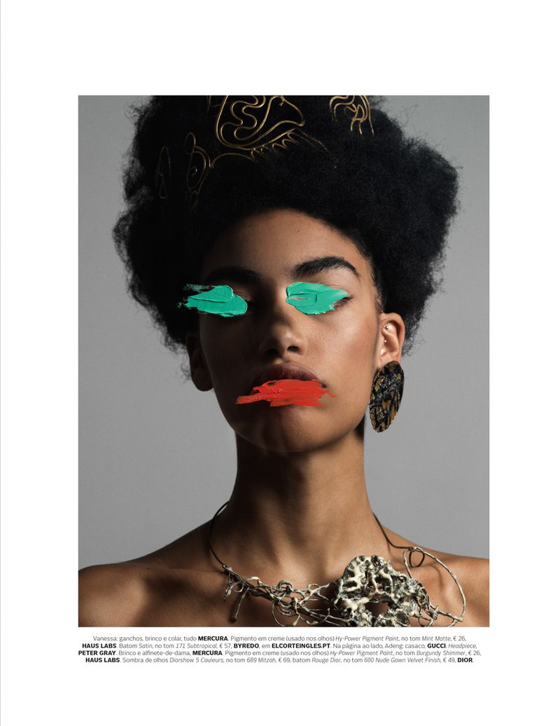 Portrait of a young adult with dramatic makeup. Painted green eyebrows and painted red lips with elaborate hair and jewellery.