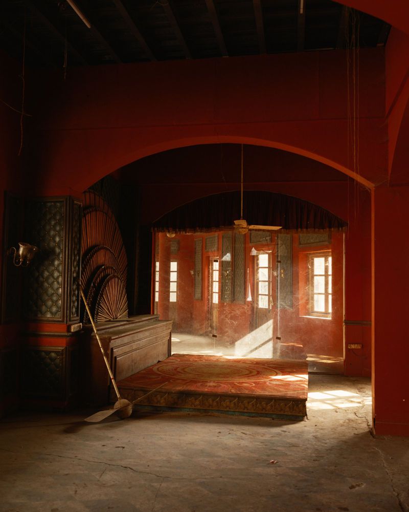 Interior with orange walls, decorative screen, and windows providing natural light illuminating room in indoor architectural photography.