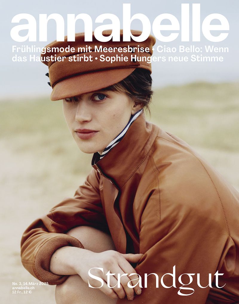 Annabelle magazine cover featuring a woman wearing a brown jacket and cap, kneeling outdoors with a neutral expression. Fashion editorial.