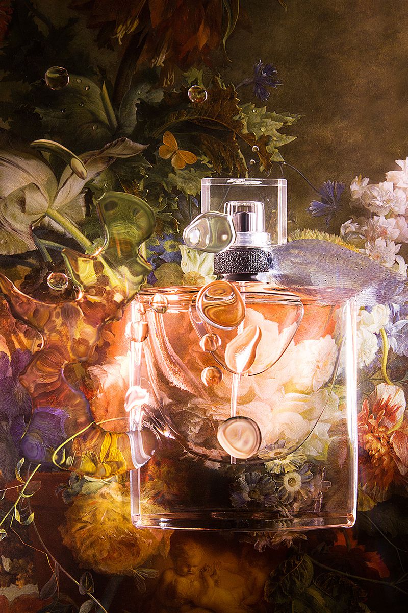 Perfume bottle with water droplets sits against a lush floral backdrop with lilies and butterflies, creating an elegant, artistic image.