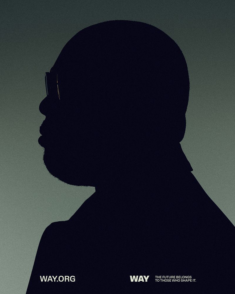 Striking silhouette portrait of a bald adult male wearing glasses and a dark suit on a gradient green background, emphasizing profile view.