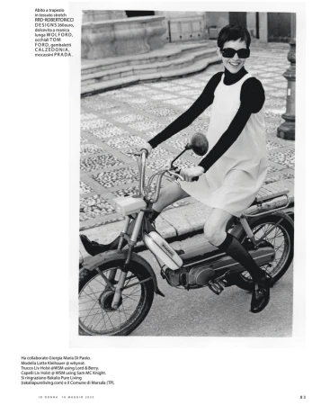 A woman in a vintage dress and sunglasses rides a moped on a patterned sidewalk in a black and white editorial fashion photograph.