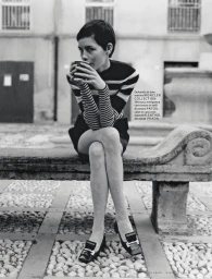 Model Lotte Kleihauer seated on a stone bench in a striped sweater drinking from a cup, photographed by Federico Sorrentino.