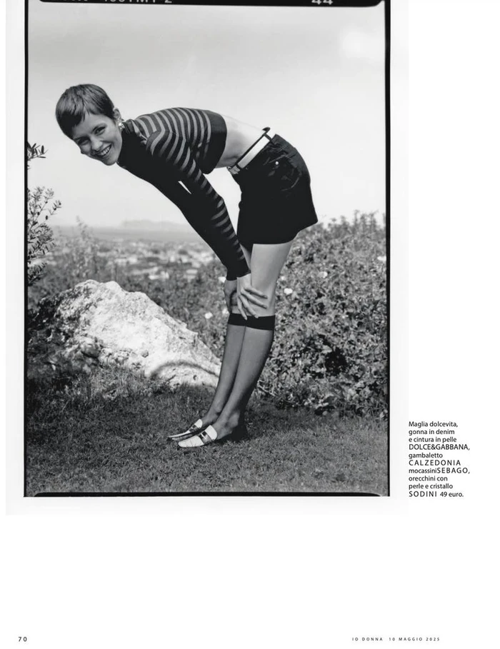 Model Lotte Kleihauer bending forward outdoors in a striped top and dark skirt, photographed by Federico Sorrentino for iO Donna.