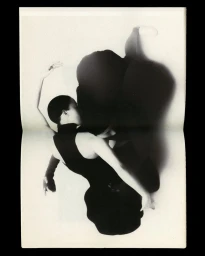 Black and white editorial fashion photography showing a model in a dark sleeveless top against a white background.