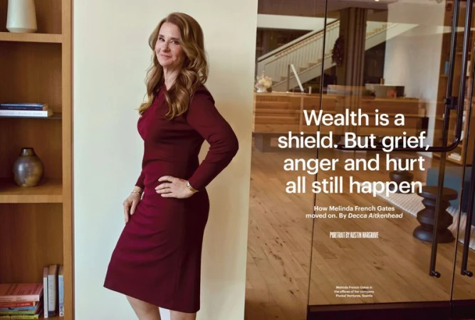 Melinda French Gates poses in a burgundy dress next to a bookshelf in an office setting with a glass door displaying a quote.