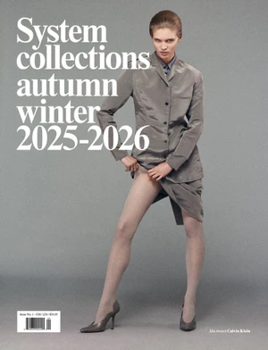 Model in grey matching jacket and skirt standing against a plain neutral background with bold white typography.