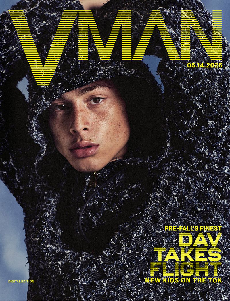 Magazine cover featuring a young adult with freckles wearing a dark hooded sweater against a light blue backdrop with yellow typographic design.