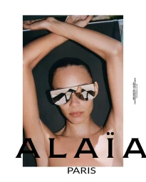 Model wearing mirrored shield sunglasses with arms raised behind her head for Alaïa campaign