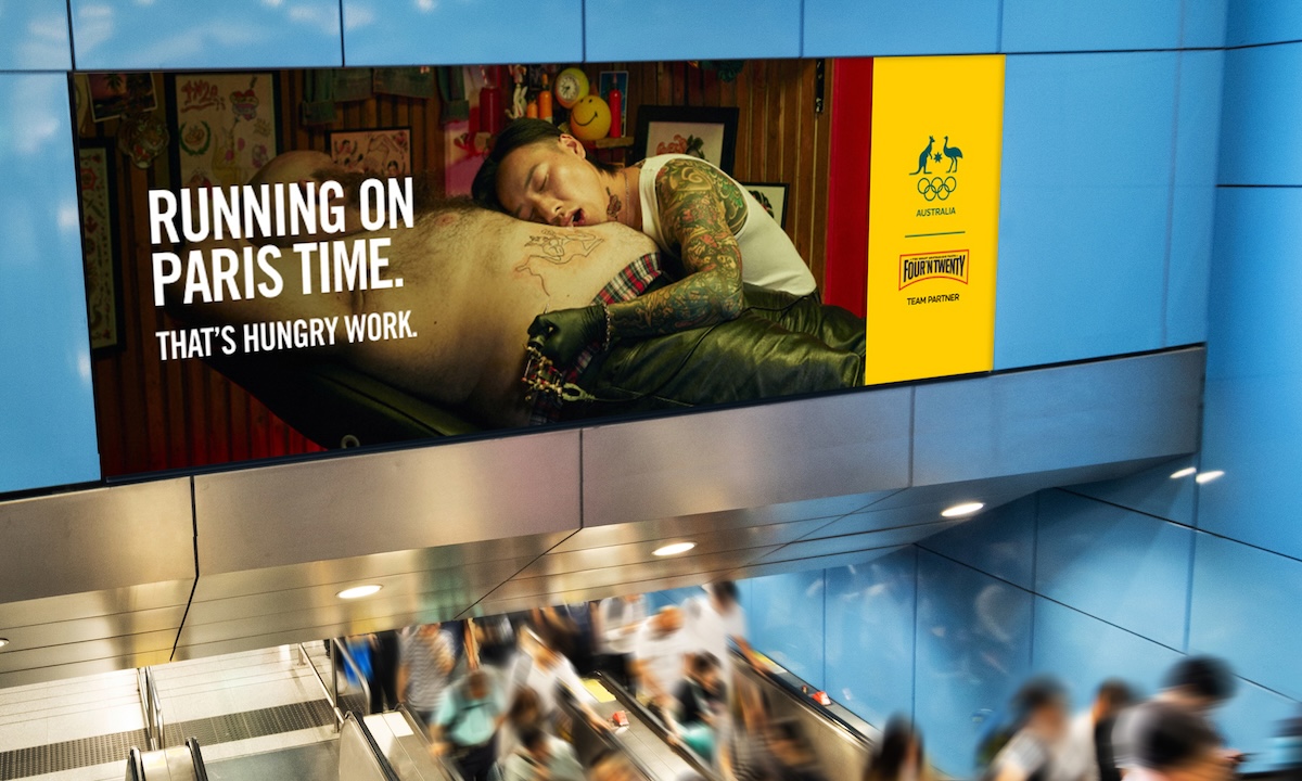 Advertisement in public transit shows a tattooed person asleep on a large body, with the text, “Running on Paris time, that's hungry work”.