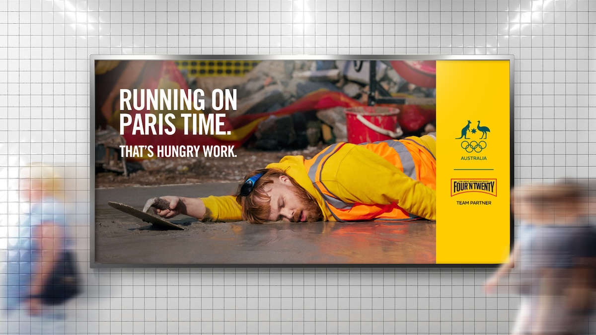 Advertisement features a construction worker lying prone on concrete next to a trowel, with overlayed text for the Olympics.