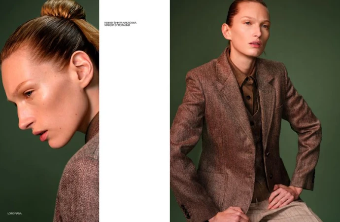 Fashion portrait of an adult female model in a brown tweed blazer with her hair in a bun, posing in a photo studio with a green backdrop.