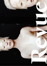 Two models with blonde hair wearing sheer sculptural garments against a black background with large Revue typography